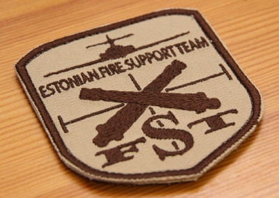 Tikitud embleem takjaalusega