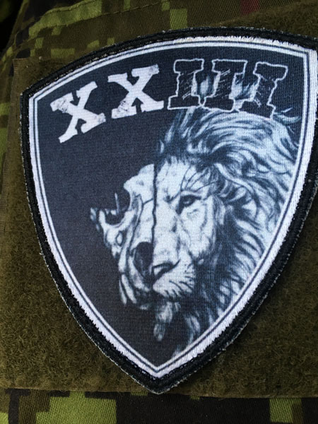 XXIII prinditud embleem takjaalusega